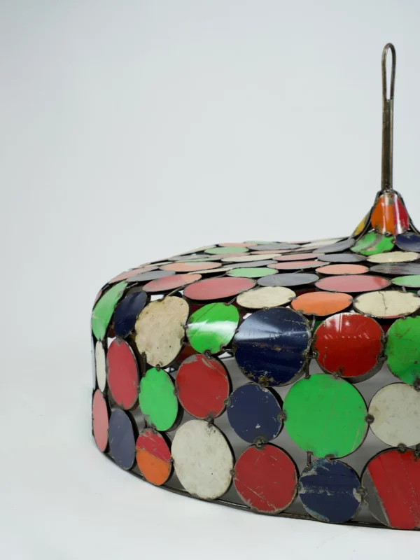 Handgemaakte kleurrijke lampenkap van gerecycled metaal met ronde patchwork-elementen in verschillende kleuren.