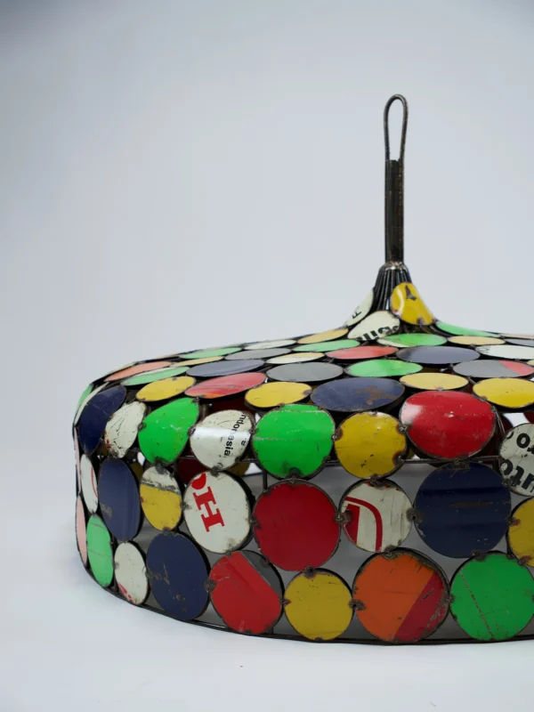 Handgemaakte kleurrijke lampenkap van gerecycled metaal met ronde patchwork-elementen in verschillende kleuren.
